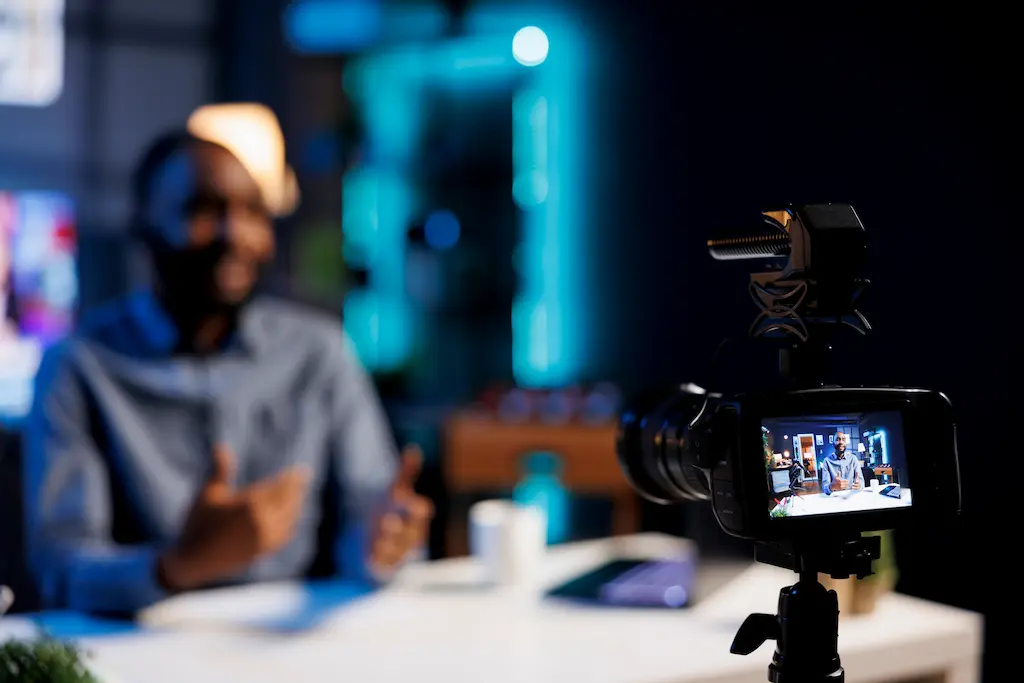 Homem trabalhando em casa, gravando um vídeo para suas redes sociais, onde trabalha como influencer digital e afiliado de iGaming, recebendo comissões de casas de apostas.